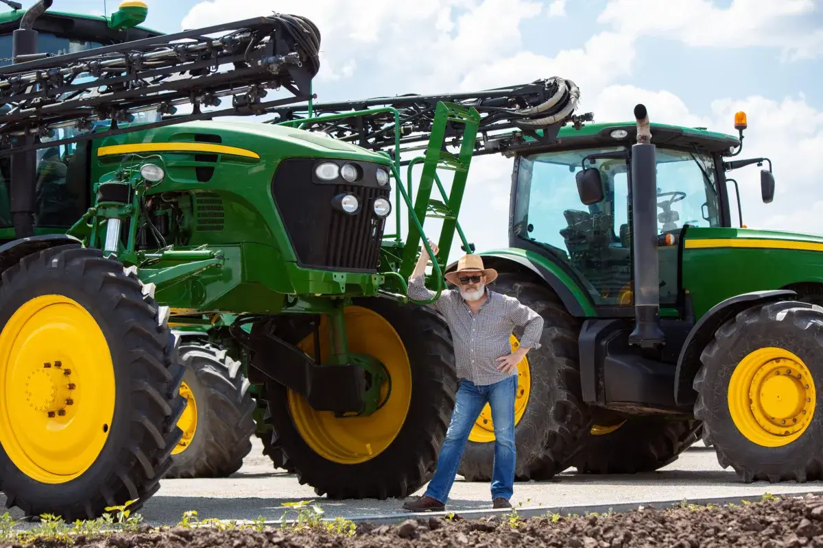 Homem próximo a um trator agrícola